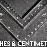 Two rulers showing measurements in inches and centimeters on a textured surface.