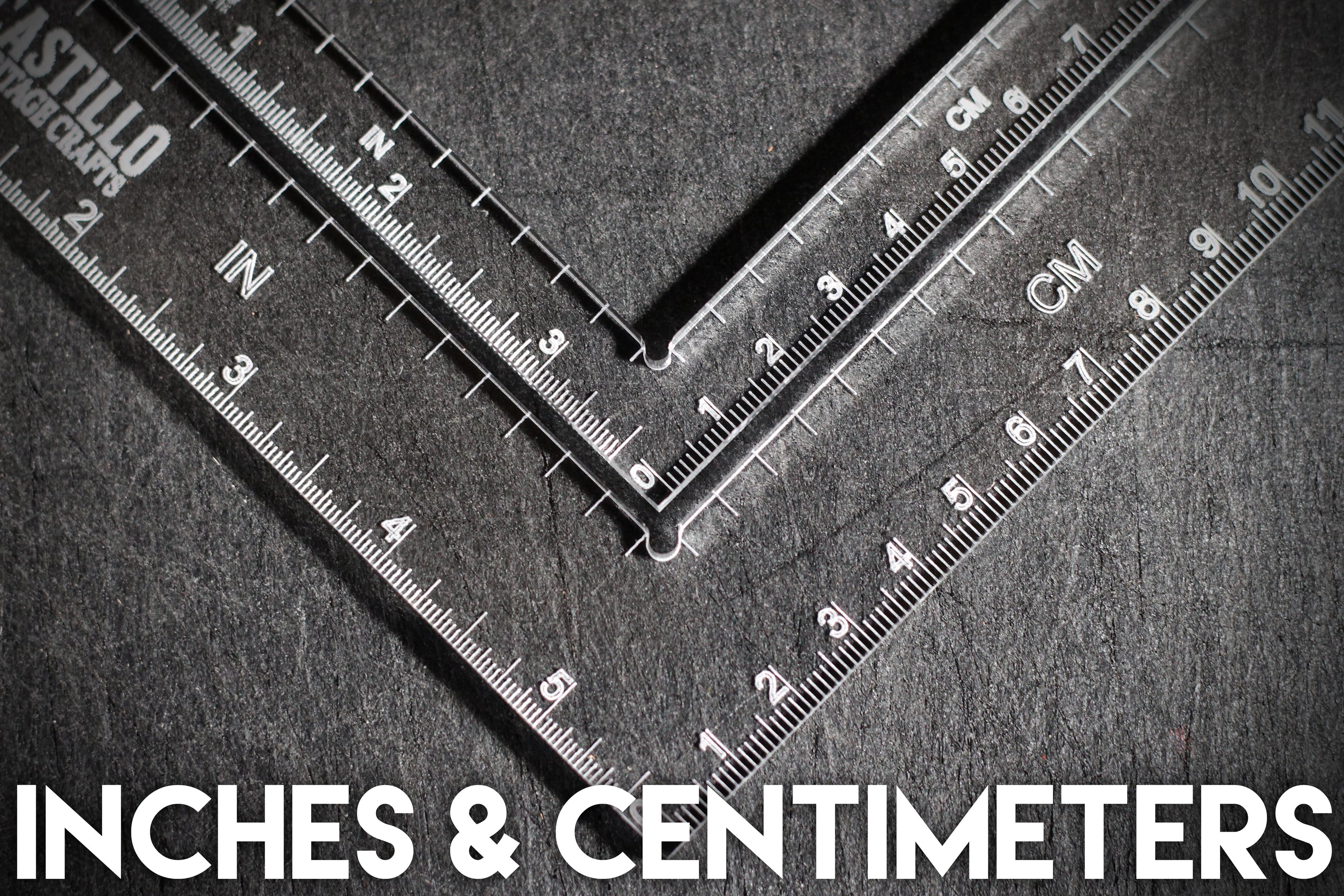 Two rulers showing measurements in inches and centimeters on a textured surface.