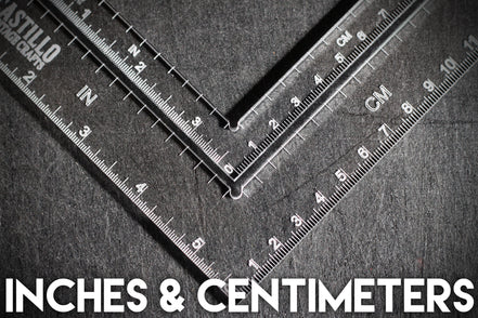 Two rulers showing measurements in inches and centimeters on a textured surface.