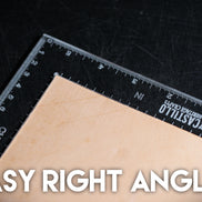 Clear plastic right angle ruler with measurement markings on a dark surface with 'Castillo Heritage Crafts' branding and 