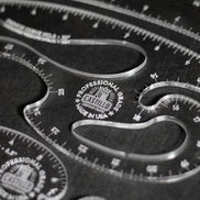 Close-up of a clear acrylic drafting ruler set with curved measurement guides and engraved Castilio branding on a dark background.